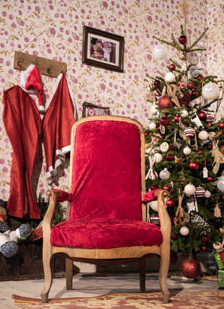 Menton, France - December 6, 2021: An empty red chair and a decorated Christmas tree - loneliness during the holiday seasonのeditorial素材