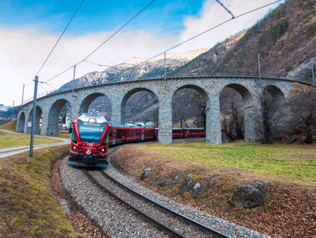 Brusio, Switzerland - February 3, 2022: Rhaetian Railway in the Albula and Bernina landscapes. Unesco heritage - Bernina express train at the helical viaduct of Brusio.のeditorial素材