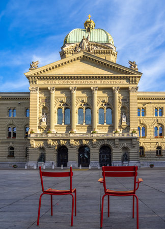 Bern, Switzerland - July 12, 2022: Two red chairs in front of the Federal parliament building in...