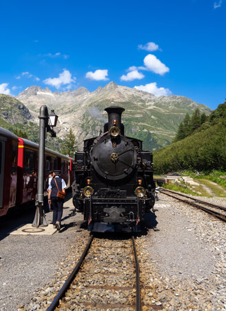 Gletsch, Switzerland - July 15, 2022: A historic train with a steam locomotive on the Furka Railway...