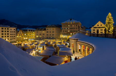 Einsiedeln, Switzerland - December 5, 2023: Christmas market in front of the Benedictine Abbey of Einsiedeln in blue hourのeditorial素材