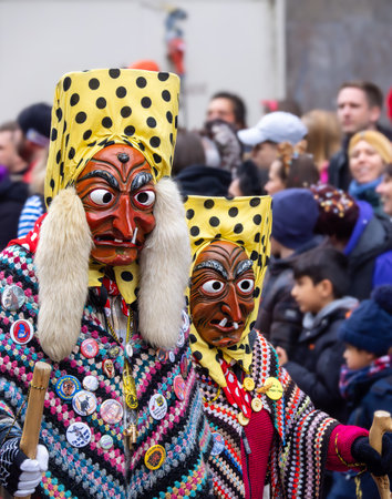 Freiburg im Breisgau, Germany - February 12, 2024: Masquerade. Beautiful masks in a carnival parade with blurred people in background.のeditorial素材