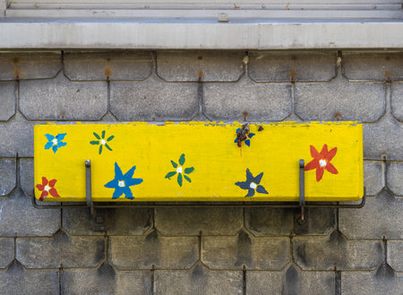 Empty outdoor yellow decorated flower pot on house wallの写真素材