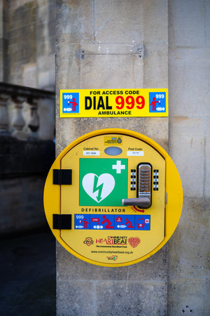 Bath, United Kingdom - December 27, 2025: Public defibrillator mounted on a wall with emergency...
