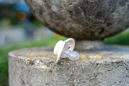 A baby pacifier on a concrete surface outdoors.の写真素材