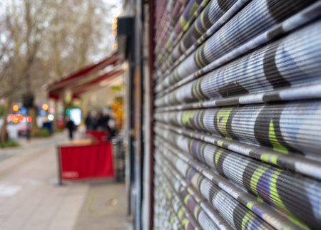 Blurred street view of London with a focus on a closed shop shutter.