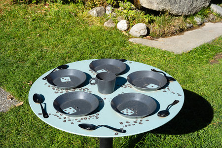 Murren, Switzerland - October 2, 2025: Outdoor table with artistic metal plates, spoons, and a cup.