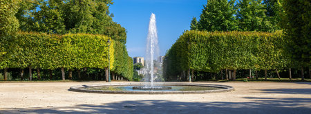 A symmetrical view of a fountain in a park of Blossac in Poitiers with trimmed trees.の写真素材