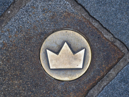 A series of bronze crowns embedded in the pavement that mark the route of the historical coronation...