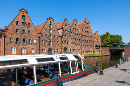 Lubeck, Germany - July 2, 2025: Historic brick buildings with stepped gables line a canal, with a...