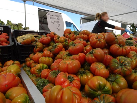 close-up of tomatoes at a market stall with price tagの写真素材
