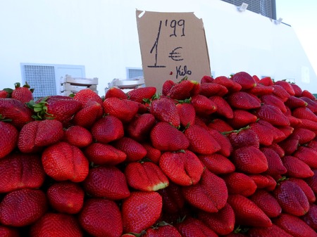 close-up of strawberries at a market stall with tag priceの写真素材
