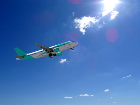 Commercial airplane taking off with cloudy skyの写真素材