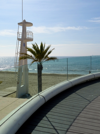 View of the beach with lifeguard tower and glass walkway in Alicante cityの写真素材