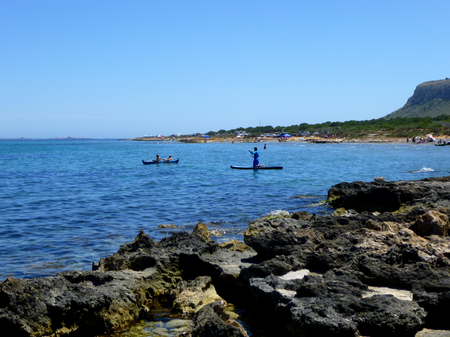 people enjoying water sports on a rocky beachの写真素材