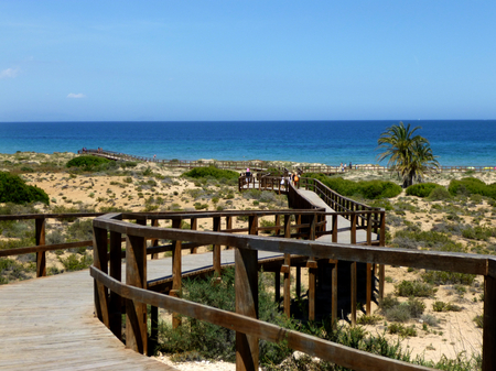 beautiful beach between sand dunes and people enjoying the summerの写真素材