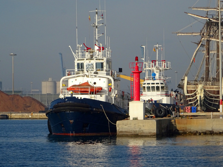 view of a tugboat moored in the harbor next to fishing boatsの写真素材