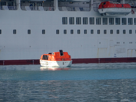 Lifeboat of a cruise ship executing mandatory safety and assistance maneuversの写真素材