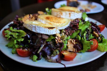 Close-up of a delicious salad with goat cheese nuts and balsamic cream. Very appetizing and colorful.の写真素材