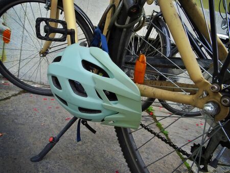 Close-up of a helmet attached to a bicycle parked in the city center. Urban mobility without pollutionの写真素材