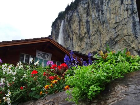 Old wooden cabin in a meadow at the foot of a rock cliff. Typical Swiss mountain landscape. Lauterbrunnen, Bern, Oberland.の写真素材