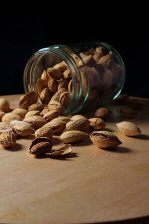 glass jar full of natural almonds with peel. Dried fruits from organic cropsの写真素材