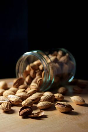 glass jar full of natural almonds with peel. Dried fruits from organic cropsの写真素材