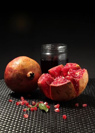 Still life of an open pomegranate with grains and seeds on dark background. Pomegranate variety fruit Mollar from Elche, Alicante.の写真素材