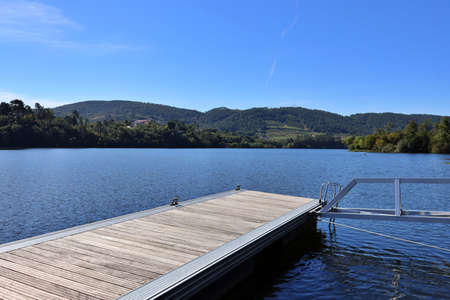 view of a jetty on the shore of a lake. Quiet scene of an ideal place to relax and practice water sports. Pontoon, jetty, dock.の写真素材