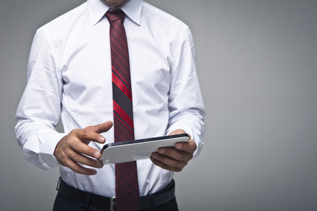 Businessman with finger touching screen of a digital tabletの写真素材