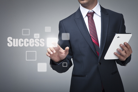 Businessman with tablet pushing on a touch screen interfaceの写真素材