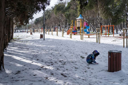 photo of a little child having fun playing in the forest in a happy snowy day in winter holidayの写真素材