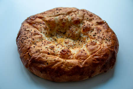 Khachapuri with sesame seeds on a white background.