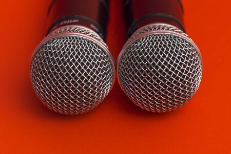 Two karaoke microphones on a red backgroundの写真素材