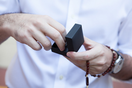 Man holds gift from black box in his handsの写真素材