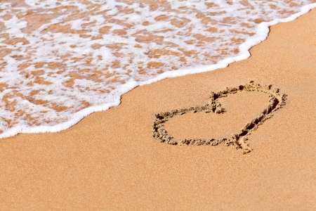 heart in the sand in a holiday beachの写真素材