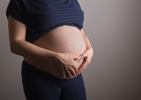 pregnant woman touching her belly with handsの写真素材