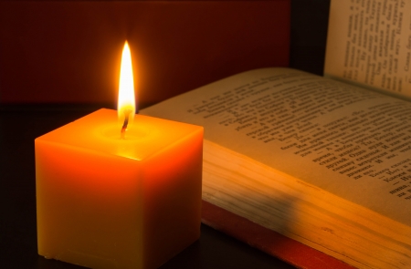 Burning candle and the open bookの写真素材