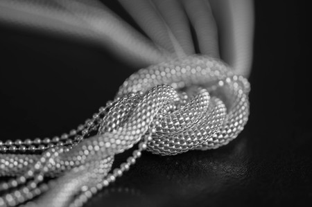Metal necklace on the black , tied in the knotの写真素材