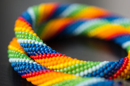 Knitted necklace from beads of a rainbow colors close upの写真素材