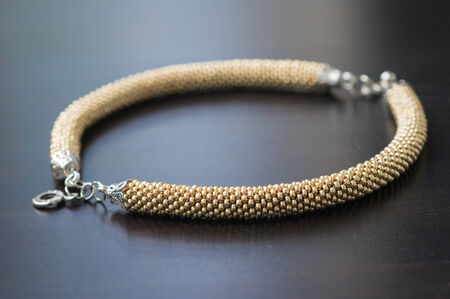 Bracelet of gold color on a wooden backgroundの写真素材