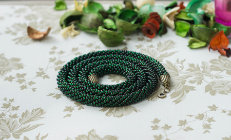 Necklace from green beads on a textile backgroundの写真素材
