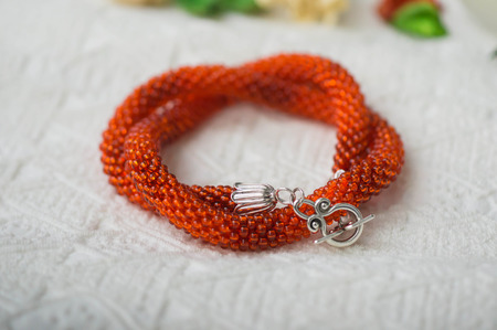 Orange necklace from beads on a textile backgroundの写真素材
