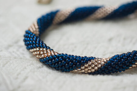 Necklace fragment from beads of blue and gold color close upの写真素材