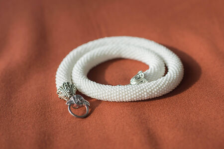 White necklace from beads on a textile backgroundの写真素材
