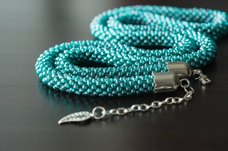 Necklace from beads of color aquamarine against a dark backgroundの写真素材