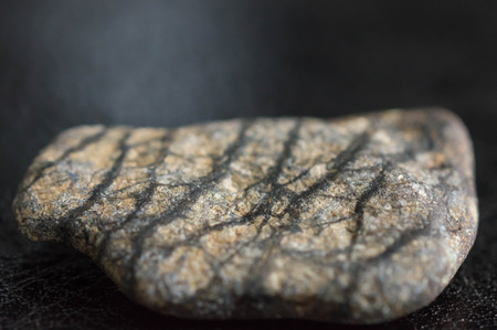 Stone with drawing on a dark surface