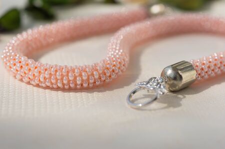 Pink necklace from beads on a textile backgroundの写真素材