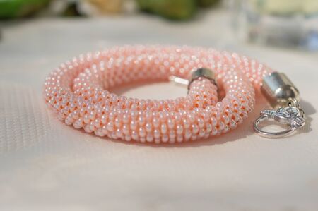 Pink necklace from beads on a textile backgroundの写真素材