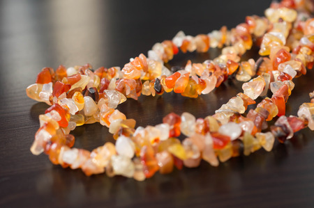 A necklace of stone beads on a wooden surface close-up